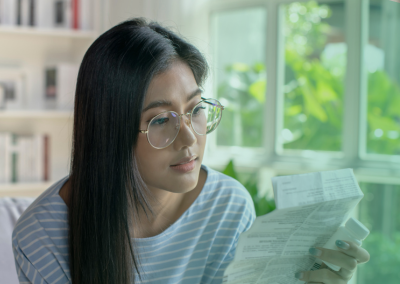 Young Asian woman reading a pic of paper